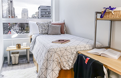 Suite meublée Campus1 chambre avec un lit jumeau et un bureau.